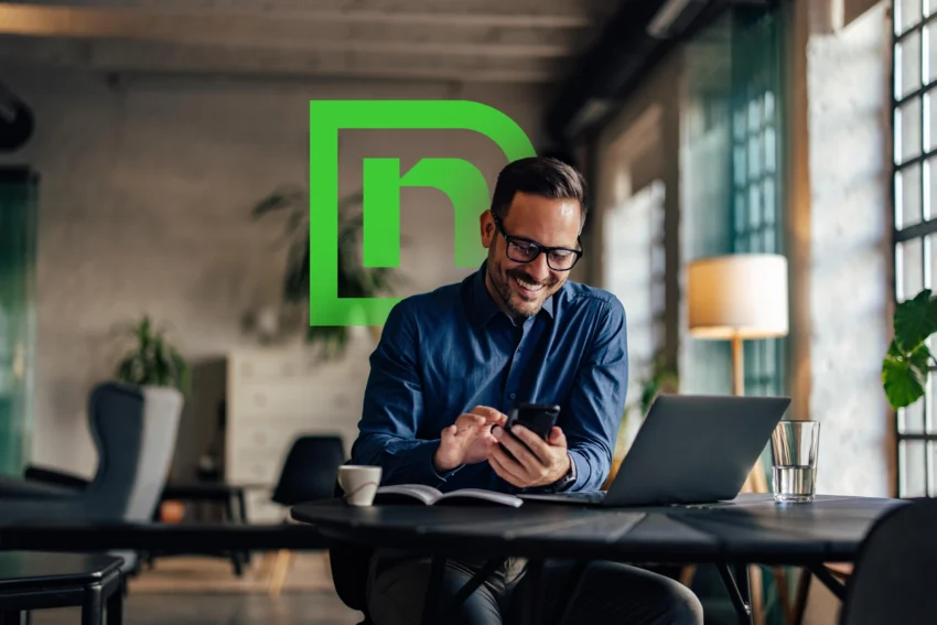 Man working on laptop with Naviant logo behind him