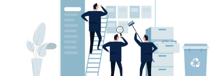 Three people in business attire tackle data cleanup by organizing documents on a wall using a ladder, magnifying glass, and paint roller, with office furniture and a recycling bin nearby.