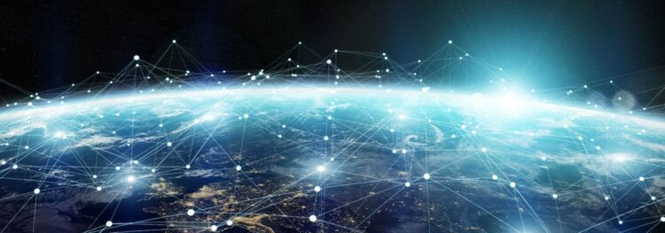 View of Earth from space with a digital network of interconnected points and lines overlaying the planet, symbolizing global connectivity and communication.