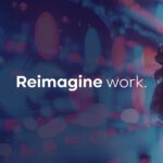 A person with a beard and sunglasses looks at digital screens with the words "Reimagine work." displayed in the center.