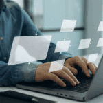 Person typing on a laptop with a transparent digital flowchart diagram overlayed, suggesting workflow or process management.