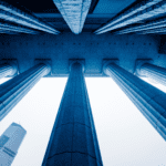 Low-angle view of tall stone columns of a government building, with a modern skyscraper in the background—an inspiring scene for public sector leaders exploring government AI use cases to shape the future.