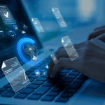 Hands typing on a laptop keyboard with digital document and cloud icons overlaid, representing data management and online file processing—an essential foundation for building an enterprise knowledge layer for insurance.